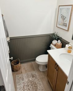 a white toilet sitting in a bathroom next to a wooden sink vanity and counter top