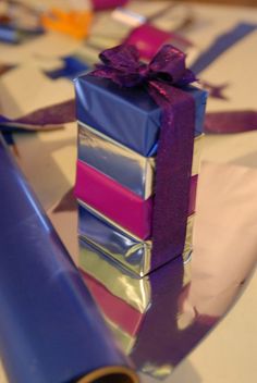 a stack of wrapped presents sitting on top of a table