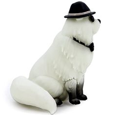 a white dog wearing a hat and sitting down