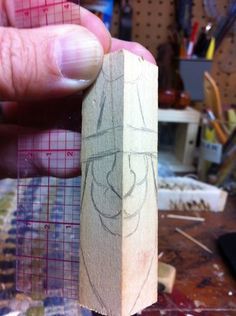 a person holding a piece of wood with a drawing on it