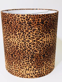 a leopard print lamp shade with a white light in the middle and black trim around it