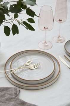 the table is set with silverware and wine glasses on it, along with napkins