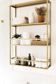 the shelves in this bathroom are filled with plants and other things to put on them