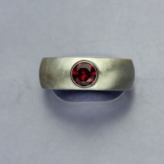 "Ruby Silver Ring, Lab Faceted Red Ruby Sterling Silver, Wide Band, Unisex Ring Beautiful ring that started out as a hand carved wax. I then cast the wax sculpture of the ring with the finest sterling silver using the lost wax casting method. The result was this stunning ring, featuring a lab created Ruby that l set in the center. I gave this ring a matte finish to the .925 Sterling Silver. Ring is Size 10 This Ruby gemstone has the same optical and physical properties as a natural Ruby. The onl Modern Red Ruby Ring For Wedding, Modern Red Ruby Wedding Ring, Hand Forged Ruby Ring In Red, Hand Forged Red Ruby Ring, Hand Forged Red Jewelry For Anniversary, Modern Handmade Red Ring, Modern Handmade Red Rings, Modern Red Garnet Rings, Ruby Silver Ring