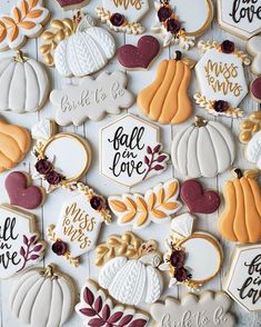 many decorated cookies are arranged on a white surface with fall words and pumpkins in the background