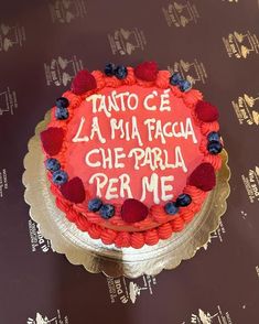 a cake with writing on it sitting on top of a table next to a wall