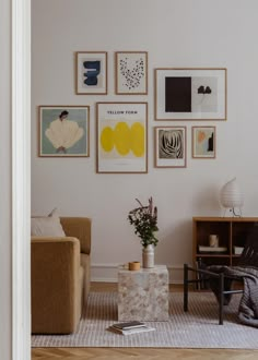 a living room filled with furniture and pictures on the wall