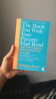 the book you wish your parents had read is held up in front of a person's face