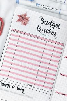 a planner with the words budget tracker written on it next to a pair of scissors