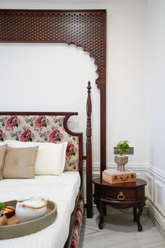 a bed sitting in a bedroom next to a table with a tray on top of it