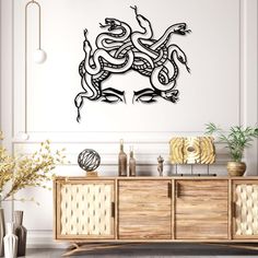 a room with a large wall decal that has a snake on the sideboard