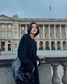 a woman standing in front of a large building