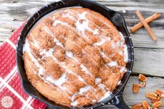 a skillet filled with cinnamon bundt cake sitting on top of a red and white towel