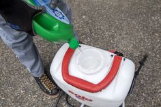 a person is pouring water into a container on the back of a small cart with wheels