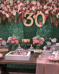 a table topped with donuts and pastries under a sign that says 30 on it