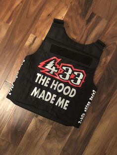 the hood made me shirt is laying on top of a wooden floor with wood floors