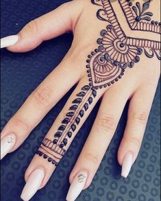 a woman's hand with henna tattoos on it