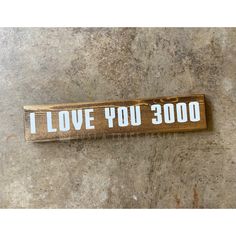 a wooden sign that says i love you 3000 on it, sitting on the ground