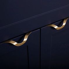 a close up view of the handles on a blue cabinet with gold trimmings