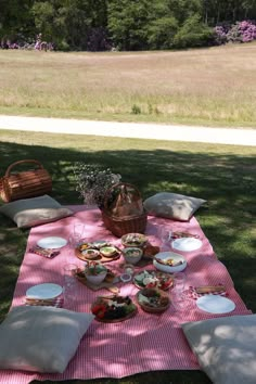 a picnic blanket with plates and bowls on it