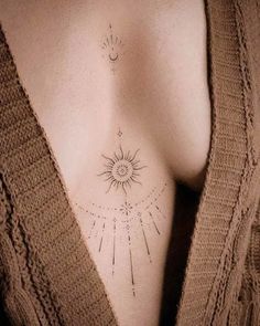 a woman's chest with the sun and stars tattoo on her left side ribcage