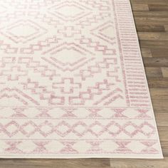 a pink and white area rug on the floor in a room with hardwood floors,