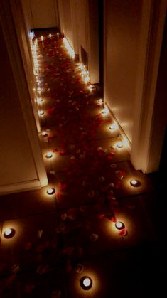 the hallway is decorated with candles and rose petals on the floor in front of the door