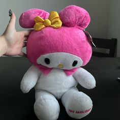 a hello kitty stuffed animal with a bow on it's head sitting on a table