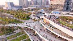 an aerial view of people walking and riding on the walkways in front of buildings