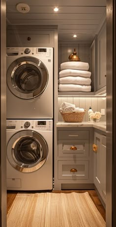 a washer and dryer in a small room with white towels on the shelves