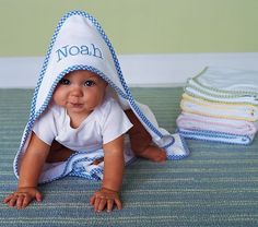 a baby is laying on the floor under a towel with his name written on it