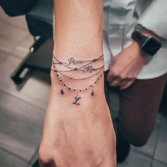 a woman's wrist with a tattoo on it