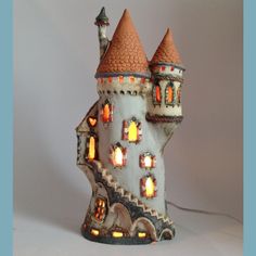 a castle lamp is lit up on a white background with an orange light coming from the top