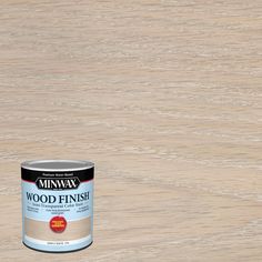 a can of wood finish sitting on top of a wooden floor