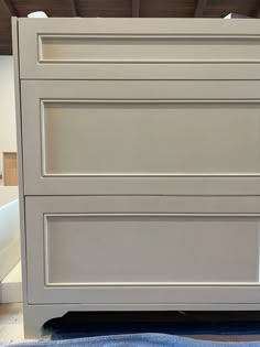 a white dresser with three drawers on top of it