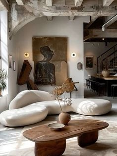 a living room filled with lots of furniture next to a painting on the wall above a coffee table