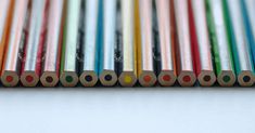 several colored pencils lined up in a row