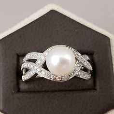 "Pearl & Diamond Ring Featuring a Genuine White Saltwater Pearl measuring approximately 7.8mm. Set in a 14k White Gold Braided band Full of Genuine sparkling white Diamonds, beautiful to complement a wedding dress. The Diamond total weight equals approximately .50 carats. A unique, bright white gold diamond statement ring, for any occasion. **Ring size: 6.5 **Pearls are the official June Birthstone. **Diamonds are an official April Birthstone. **This item can be sized up 2 sizes for an addit White Gold Pearl Ring With Brilliant Cut For Anniversary, Anniversary White Gold Pearl Ring With Brilliant Cut, Elegant White Gold Halo Gemstone Ring, Fine Jewelry Platinum Pearl Ring With Brilliant Cut, Fine Jewelry Pearl Ring With Round Band For Anniversary, Fine Jewelry White Gold Pearl Ring With Brilliant Cut, Fine Jewelry Round Cut Pearl Ring For Anniversary, White Gold Pearl Ring With Center Stone, Round Cut, White Gold Pearl Ring With Cubic Zirconia Center Stone