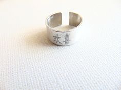 "Chinese letters ring, Happiness Ring, Chines symbol, adjustable Silver band ring, Personalized engraved Ring, inspirational & spiritual Ring. This ring has a Chinese symbol that means HAPPINESS ! I can engrave these Chinese symbol: LOVE, LUCK, LIFE, HAPPINESS This ring is made with aluminum with brushed finish. It has a unisex style so you can match rings. The ring is an open cuff adjustable design, and will best fit US sizes 6.25 through 7.25. Measurement: ** Ring width is about 0.45\" ** Inspirational Adjustable Silver Rings, Adjustable Silver Rings With Meaningful Style, Adjustable Silver Meaningful Rings, Adjustable Inspirational Stamped Rings, Symbolic Engraved Nickel-free Ring As Gift, Symbolic Nickel-free Engraved Ring Gift, Personalized Adjustable Symbolic Rings, Adjustable Symbolic Personalized Rings, Adjustable Rings With Engraving Option