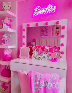 a pink room with hello kitty decorations and lights on the wall, including a vanity