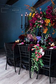 a table with flowers and candles is set for an elegant dinner or party in the dining room