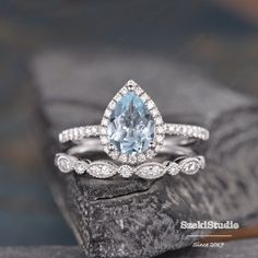 an engagement ring with a pear shaped aqua blue topazte surrounded by white diamonds