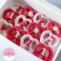 a box filled with lots of pink decorated cookies in the shape of hearts and flowers