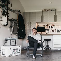 a man sitting on a chair in front of a garage