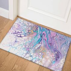 a door mat with an abstract design on the floor in front of a white door