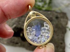 This 14K yellow gold locket has been filled with a natural terminated tanzanite crystal, and accented with faceted tanzanite gems, and sparkling Herkimer diamond quartz crystals. These are genuine and naturally occurring high grade gemstones from locations around the world, not beads or glass or synthetic stones. This high quality floating locket is US made with 14k yellow gold and glass. You will receive this exact locket and stone selection. Add on a 14K gold chain for a complete necklace, if Faceted Tanzanite Jewelry Gift, Faceted Tanzanite Jewelry For Gifts, Gold Tanzanite Pendant Jewelry, Unique Tanzanite Jewelry Gift, Unique Tanzanite Jewelry For Gifts, Gold Tanzanite Jewelry With Faceted Design, Tanzanite Crystal, Locket Gold, Floating Lockets