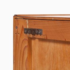 a close up of a wooden cabinet door with metal latches on the front and side