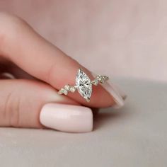 a woman's hand holding a diamond ring