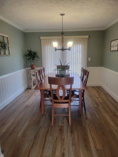 a dinning room table with chairs and a potted plant in the center is shown