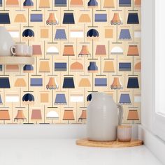 the wallpaper in this kitchen is colorful and has geometric shapes on it, as well as vases